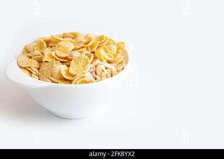 Maisflocke in der Schüssel und leerer Platz für Text isoliert auf weißem Hintergrund, Teller mit Cornflakes, gesundes Frühstückskonzept, Seitenansicht Stockfoto