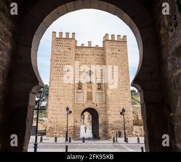 Blick auf die mittelalterliche Brücke von Alcantara über den Fluss Tejo in Toledo durch einen der Bögen in der Wand, Spanien. Stockfoto