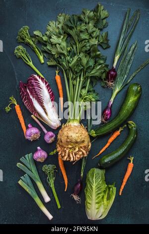 Gemüsesorten auf dunklem Hintergrund, vertikale Draufsicht, Konzept der vegetarisch gesunden Ernährung Stockfoto