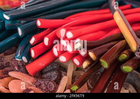 Rote, braune und schwarze Lakritzstöcke auf einem Marktstand Stockfoto