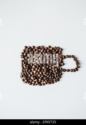 Braune Kaffeebohnen in Form Tasse auf weißem Hintergrund Stockfoto