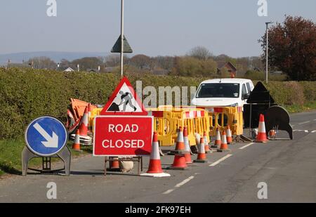 Straßenbauarbeiten und entsprechende Schilder, Kegel, Barrieren auf Taylor's Lane, Pilling, Lancashire für Reparaturen, bei denen der Asphalt in ein Straßenloch eingestürzt ist. Stockfoto
