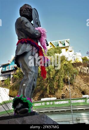 Statue, geschmückt mit Girlanden, Gesichtsmaske und Schild von Straßendemonstranten Im Jahr 2019-20 soziale Umwälzungen,,Valparaiso,Chile Stockfoto