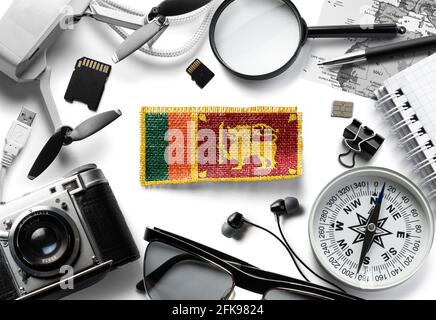 Flagge Sri Lankas und Reisezubehör auf weißem Hintergrund. Stockfoto