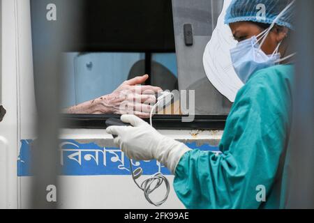 Kalkutta, Indien. April 2021. Eine medizinische Mitarbeiterin überprüft den Sauerstoffgehalt einer Patientin, die COVID-19 positiv getestet hat, bevor sie in ein COVID-Pflegekrankenhaus eingewiesen wird. Indien verzeichnet weltweit die höchste Tageszahl neuer Covid-19-Fälle. Es gibt fast 16 Millionen bestätigte Fälle, an zweiter Stelle nur die USA. Kredit: Majority World CIC/Alamy Live Nachrichten Stockfoto