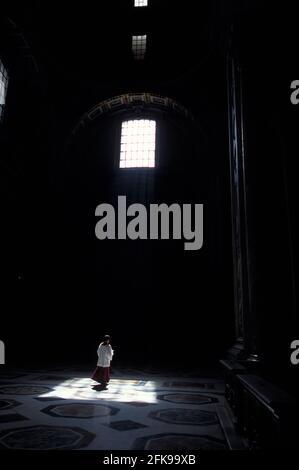 Altarjunge in einem Lichtstrahl in der Petersbasilika Vatikanstadt, Italien Stockfoto