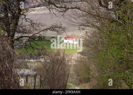 St. Mary the Virgin kleine Kirche aus dem 12. Jahrhundert, auch bekannt als „The Church in the Field“, eingerahmt in einer Frühlingslandschaft, Upwaltham, bei Petworth, West Sussex, England Stockfoto