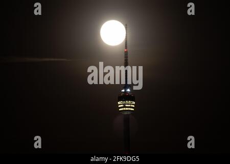 Super Vollmond hinter dem Stuttgarter Fernsehturm - der Die Antenne berührt den Mond Stockfoto