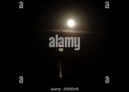 Super Vollmond hinter dem Stuttgarter Fernsehturm - der Die Antenne berührt den Mond Stockfoto