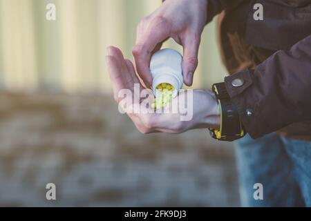 Gelbe Pillen in der Hand. Prävention von Coronavirus. Schutz der Immunität. Covid-19 Stockfoto