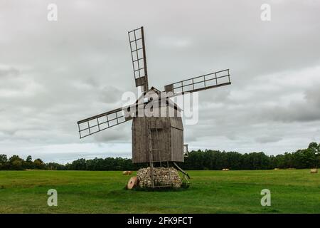 Schöne Volksarchitektur.Alte traditionelle hölzerne Windmühle in Estland gegen Wolken Himmel.verlassene ikonische Windmühle auf grüner Wiese.Sightseeing in der Stockfoto