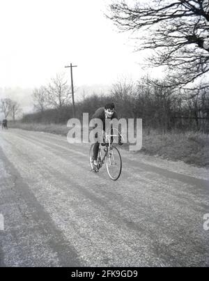 1960er Jahre, historisch, Winterzeit und draußen auf einer Landstraße, ein begeisterter Amateur-Rennradfahrer, der die Meilen in, England, Großbritannien, legt. Stockfoto