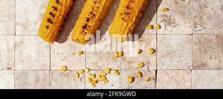 Köstliche Bio hausgemachte heiß gegrillte Maiskolben Erde getönten Geschichten Draufsicht im Hintergrund Stockfoto