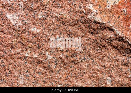 Roter Granit mit weißen und schwarzen Spritzern, Steinstruktur und Hintergrund. Hohe Auflösung, Nahaufnahme. Stockfoto