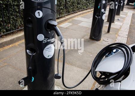 London, Großbritannien. April 2021. Das Elektroauto lädt am 20. April 2021 an der Ladestation auf der Straße im Zentrum von London. Ein neuer Bericht der Internationalen Energieagentur schlägt vor, dass es bis zum Ende des Jahrzehnts etwa 145 Millionen Elektroautos geben sollte, ein Anstieg gegenüber den heutigen 11 Millionen. (Foto von Dominika Zarzycka/Sipa USA) Quelle: SIPA USA/Alamy Live News Stockfoto