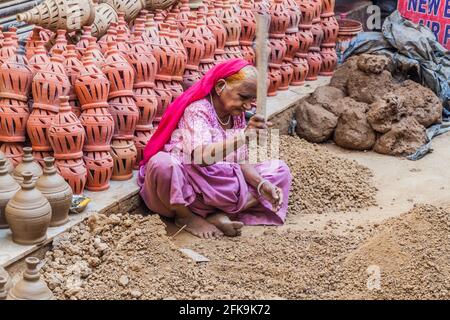 DELHI, INDIEN - 22. OKTOBER 2016: Alte Frau zermalmt Tonstücke im Zentrum von Delhi, Indien. Stockfoto