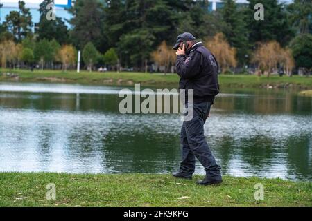 Polizist, der vor dem Hintergrund des telefoniert see Stockfoto