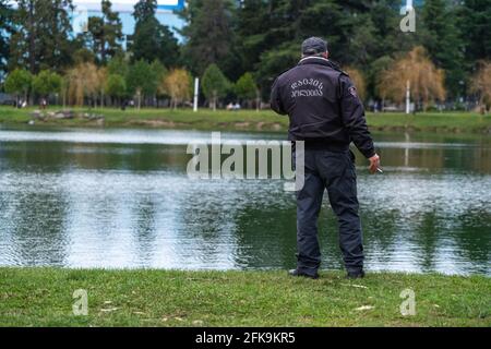 Polizist, der vor dem Hintergrund des telefoniert see Stockfoto