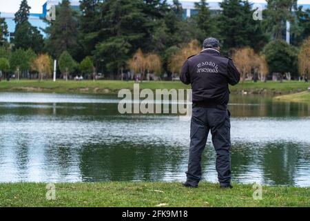 Polizist, der vor dem Hintergrund des telefoniert see Stockfoto