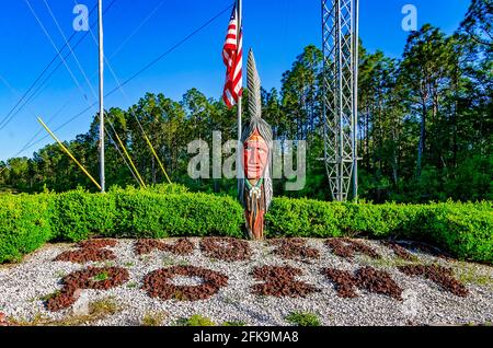 Ein hölzerner Indianer steht mit einer amerikanischen Flagge am Eingang des Indian Point RV Resort, 25. April 2021, in Gautier, Mississippi. Stockfoto