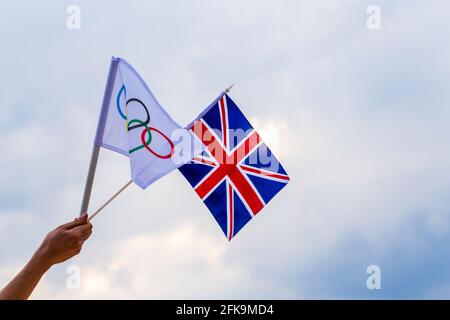 Fan winkt die Nationalflagge des Vereinigten Königreichs und die olympische Flagge mit Symbol olympics Ringe. Stockfoto