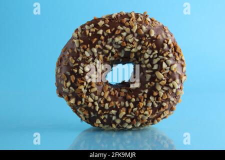 Berliner Donut rosa Schokolade liegt auf einem blauen hellen Hintergrund mit einem Ort, um eine Kopie des Stillleben Frühstück Mahlzeit Text. Stockfoto