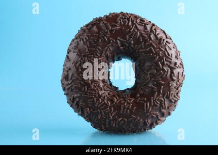 Berliner Donut rosa Schokolade liegt auf einem blauen hellen Hintergrund mit einem Ort, um eine Kopie des Stillleben Frühstück Mahlzeit Text. Stockfoto