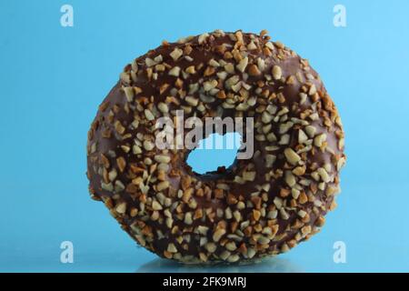 Berliner Donut rosa Schokolade liegt auf einem blauen hellen Hintergrund mit einem Ort, um eine Kopie des Stillleben Frühstück Mahlzeit Text. Stockfoto