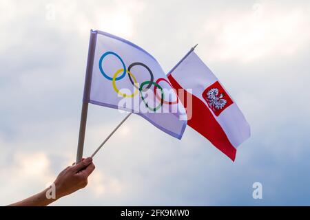 Fan winkt die Nationalflagge Polens und die olympische Flagge mit Symbol-olympischen Ringen. Stockfoto