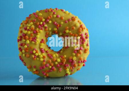 Berliner Donut rosa Schokolade liegt auf einem blauen hellen Hintergrund mit einem Ort, um eine Kopie des Stillleben Frühstück Mahlzeit Text. Stockfoto