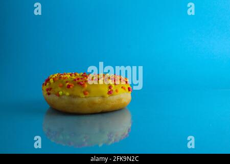 Berliner Donut rosa Schokolade liegt auf einem blauen hellen Hintergrund mit einem Ort, um eine Kopie des Stillleben Frühstück Mahlzeit Text. Stockfoto