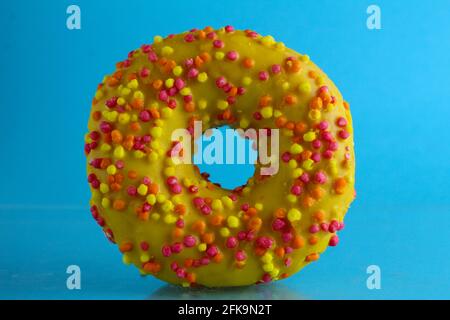 Berliner Donut rosa Schokolade liegt auf einem blauen hellen Hintergrund mit einem Ort, um eine Kopie des Stillleben Frühstück Mahlzeit Text. Stockfoto