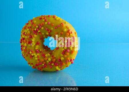 Berliner Donut rosa Schokolade liegt auf einem blauen hellen Hintergrund mit einem Ort, um eine Kopie des Stillleben Frühstück Mahlzeit Text. Stockfoto