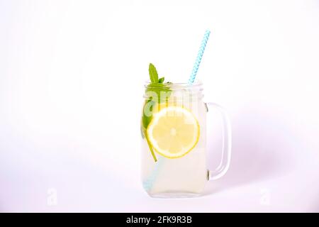 Eiskalte Lavendellimonade, Zitrone, Stroh. Klassischer Mojito-Cocktail, alkoholfreies Getränk mit Eis im alten Einmachglas-Glas auf hellweißem Isol Stockfoto