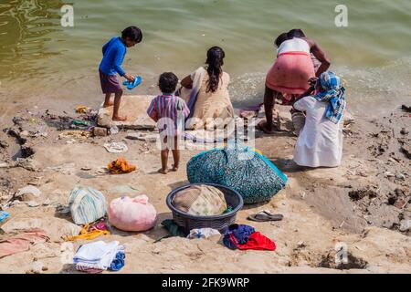VARANASI, INDIEN - 25. OKTOBER 2016: Eine Familie wäscht ihre Kleidung an den Ghats-Flusstreppen des Ganges in Varanasi, Indien Stockfoto