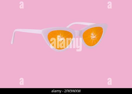 Trendige Sommeridee aus Sonnenbrillen und frischen Scheiben Orangenfrucht. Kreatives Minimalkonzept für Urlaub, Reisen, Strand und Entspannung. Artwork-Design Stockfoto