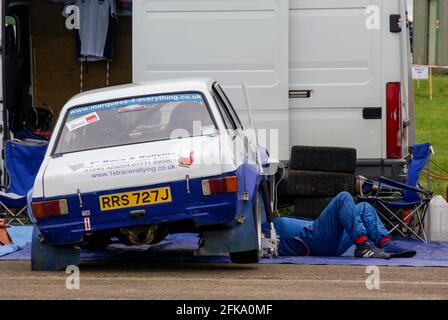 Richard Burns Memorial Rally bei RAF Marham, Norfolk, Großbritannien, mit Mechaniker, der unter einem klassischen 1971 1600 ccm Ford Escort Rallye-Auto arbeitet Stockfoto