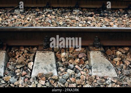 Nahaufnahme der Metallbahn mit Steinen und Beton, alte Technik Stockfoto