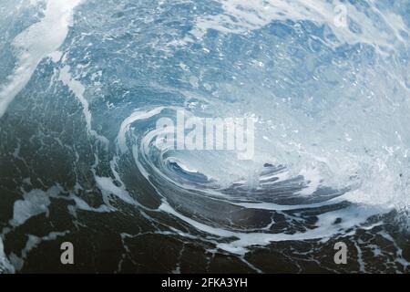 In einer Welle, die an einem Strand bricht Stockfoto