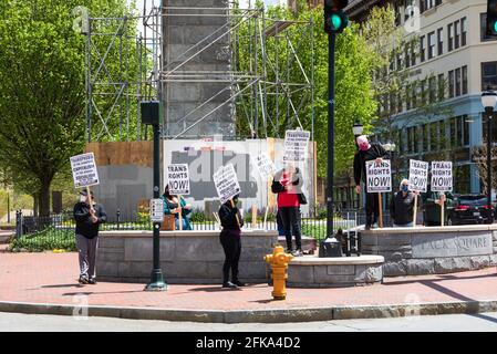 ASHEVILLE, NC, USA-25 APRIL 2021: Acht Covid-maskierte Menschen auf dem Pack Square halten Schilder mit der Aufschrift „Trans Rights Now“ und prosozialistische Botschaften. Stockfoto