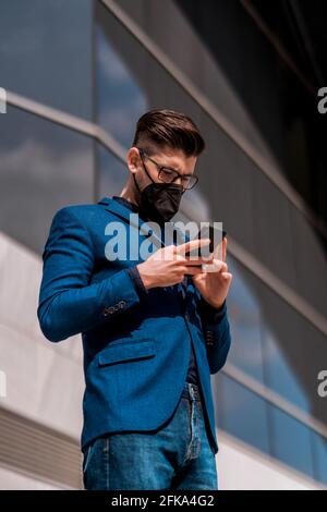 Junge gut aussehender Geschäftsmann in der Stadt auf seinem Gerät Stockfoto