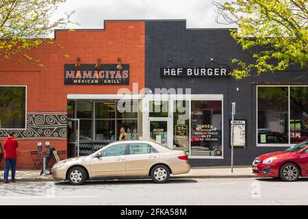 ASHEVILLE, NC, USA-25 APRIL 2021: Mamacitas Mexican Grill und H und F Burger Fassaden auf Biltmore Ave. Zwei Personen. Stockfoto