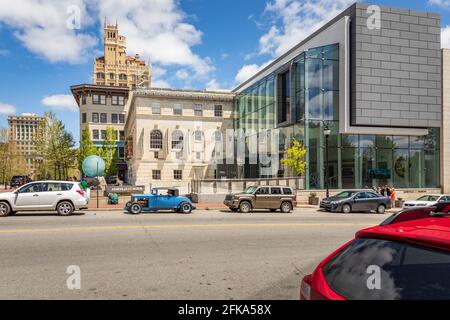 ASHEVILLE, NC, USA-25 APRIL 2021: Das Asheville Art Museum, steht vor dem historischen Jackson Building, mit dem City Hall in der Rückseite. Stockfoto