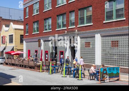 ASHEVILLE, NC, USA-25 APRIL 2021: Rankin Vault Cocktail Lounge, an der One Rankin Avenue, mit belebten Sitzgelegenheiten auf dem Bürgersteig an einem sonnigen Frühlingstag. Menschen. Stockfoto