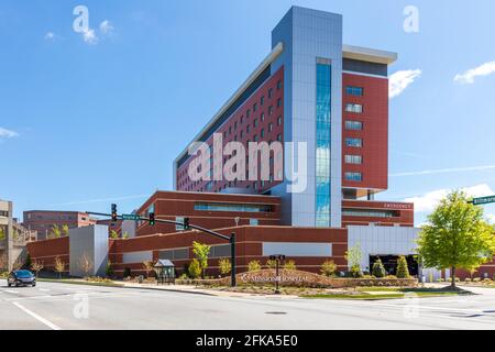 ASHEVILLE, NC, USA-25 APRIL 2021: Mission Hospital, Ecke Biltmore und Hospital Drive. Schild und Gebäude. Blauer Himmel, Frühlingstag. Stockfoto