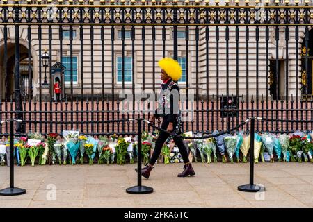 Eine junge Britin zollt Prinz Philip ihren Respekt, der kürzlich durch das Verlegen von Blumen vor den Toren des Buckingham Palace, London, Großbritannien, verstorben war. Stockfoto