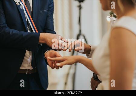 Flacher Fokus eines Bräutigams, der den Ring auf ein legt Der Finger der Braut während der Hochzeitsfeier Stockfoto