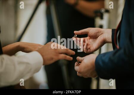 Flacher Fokus eines Bräutigams, der den Ring auf ein legt Der Finger der Braut während der Hochzeitsfeier Stockfoto