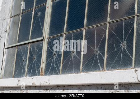 In einem verlassenen Industriegebäude in Klamath Falls, Oregon, haben Einschusslöcher alte Fenster zerstört. Stockfoto