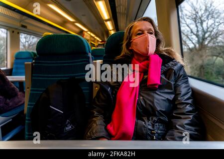 Eine Frau reist mit dem Zug während der britischen Covid-Krise 19, Sussex, Großbritannien. Stockfoto